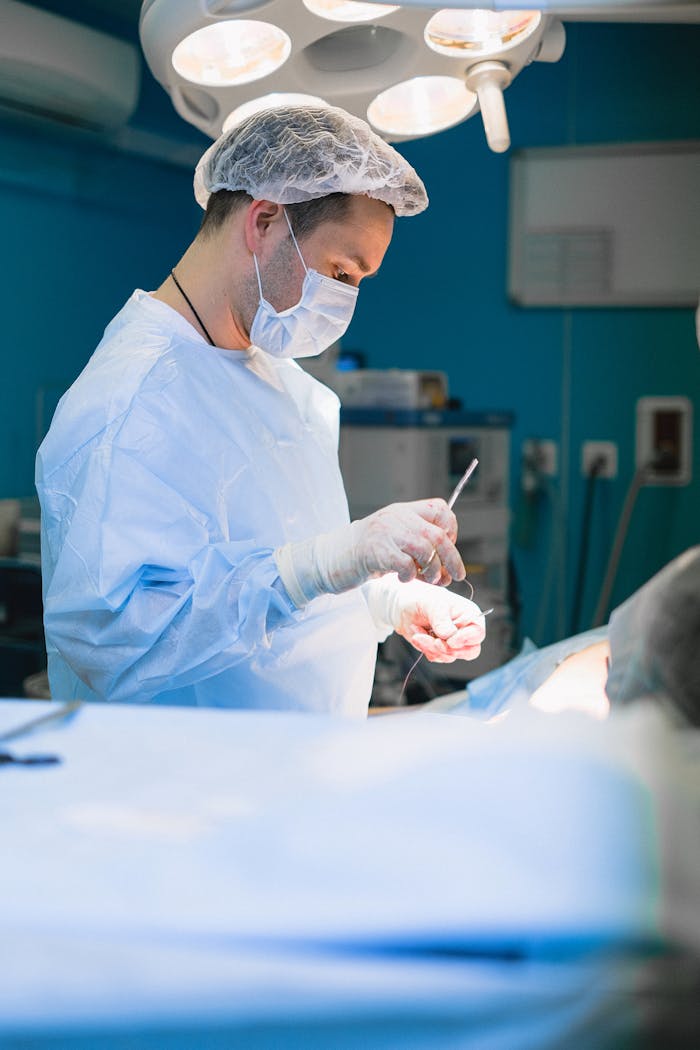 A focused surgeon in a modern operating room performing a surgery under bright lights.